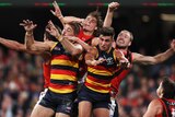 A large pack of Essendon and Adelaide players compete for the ball
