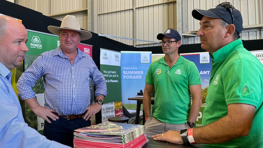 Four men stand around talking