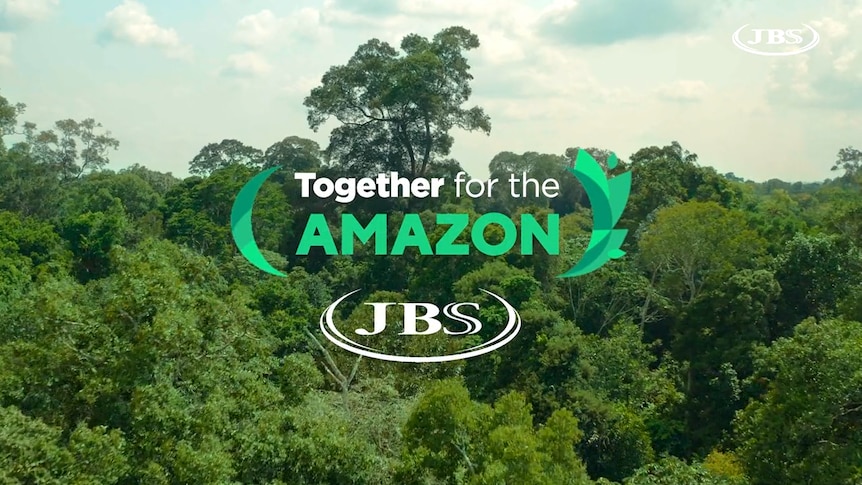 A still from a company video showing the tops of trees, the words "Together for the Amazon" and a JBS logo.
