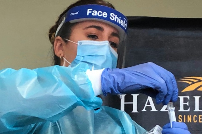 Bendigo Health graduate Nurse, Hannah Lucas secures a saliva swab test for COVID 19 testing