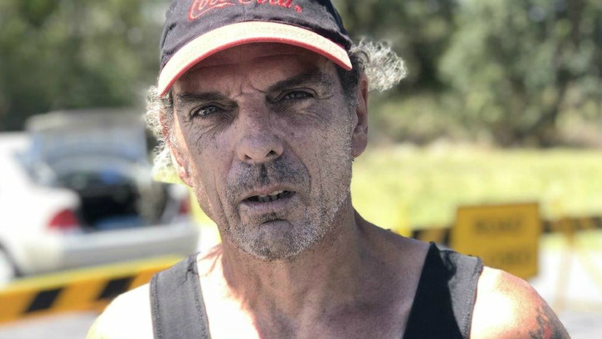 man in cap and black singlet out in the sun