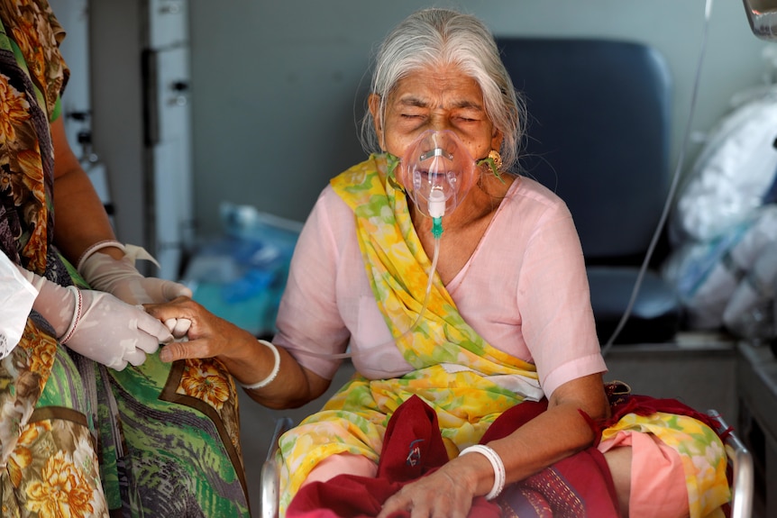 A woman receives oxygen in India. 