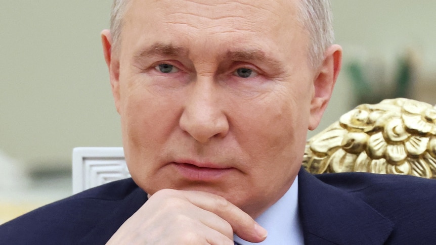 Vladimir Putin resting his chin on his hand 