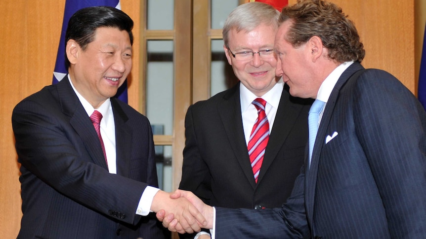 Xi Jinping and Andrew Forrest shake hands, as Kevin Rudd looks on.