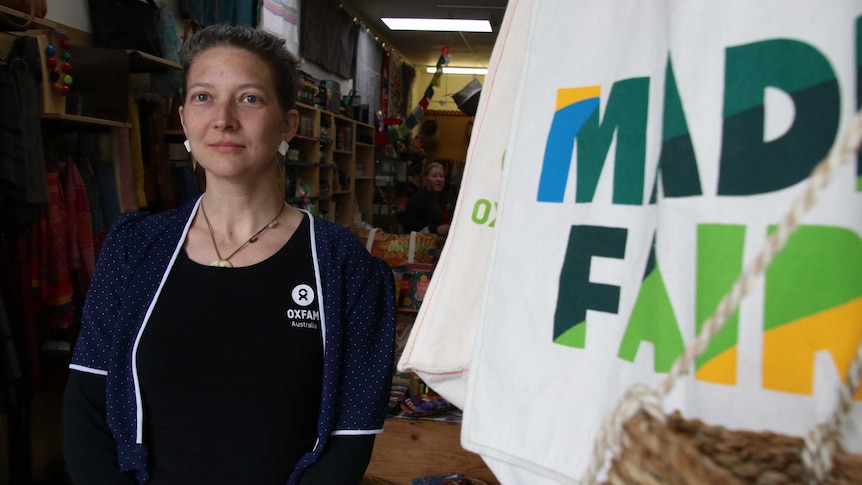 picture of Claudine Schmidt who runs the Oxfam shop in Fremantle standing next to a Fair Trade sign