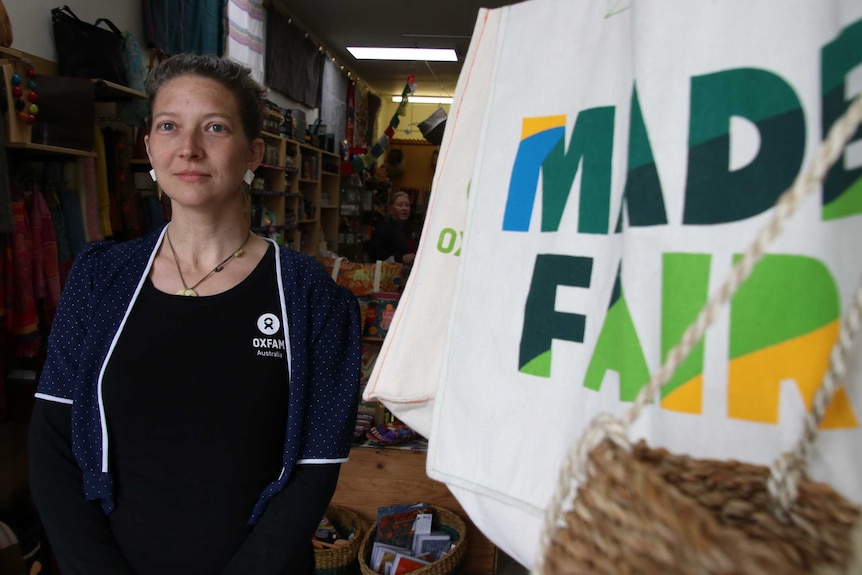 picture of Cornelia Schmidt who runs the Oxfam shop in Fremantle standing next to a Fair Trade sign