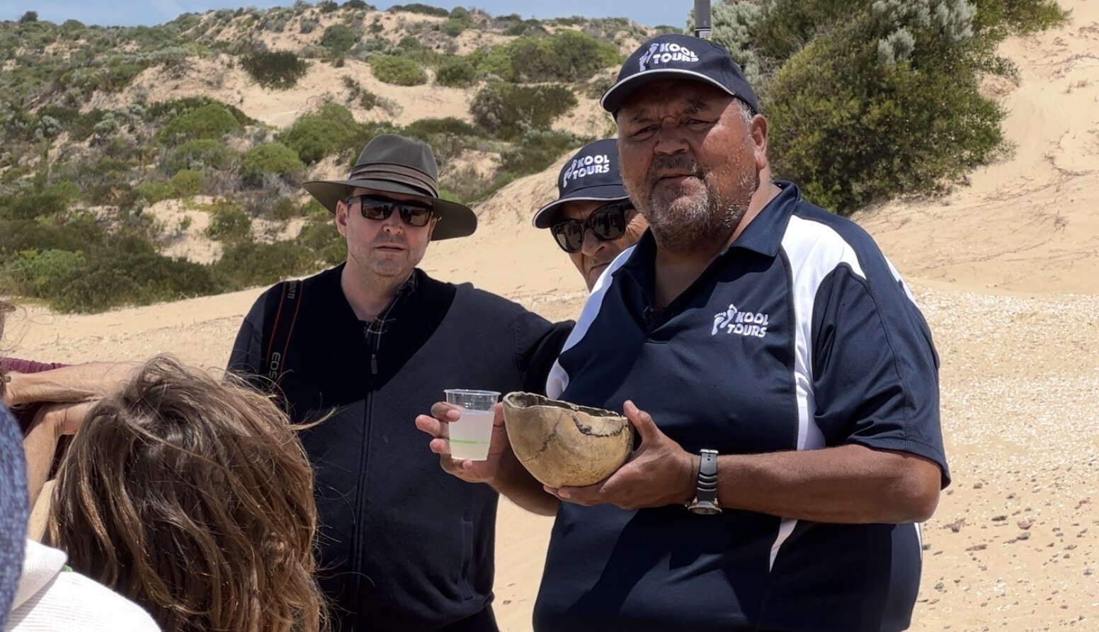 Un grupo de personas entre dunas de arena en un día soleado.