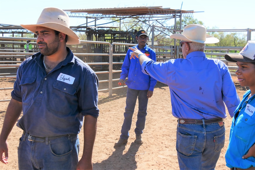 Cattle workers getting directions from station hands.