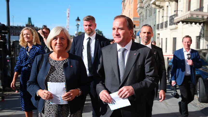 Stefan Lofven arrives with his wife Ulla to cast their votes