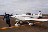 Experienced pilot Jamie McAlindon holding the propeller of a light plane.