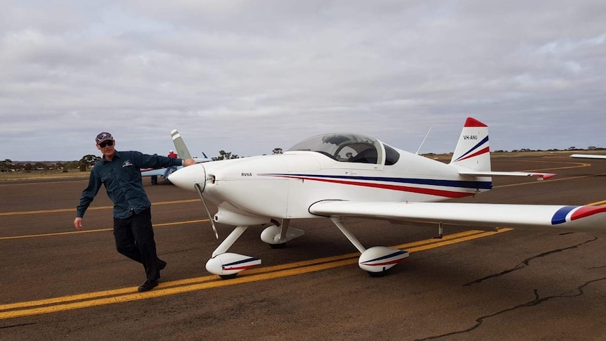 Experienced pilot Jamie McAlindon holding the propeller of a light plane.