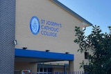 A large brick building bearing an emblem and the name "St Joseph's Catholic College".