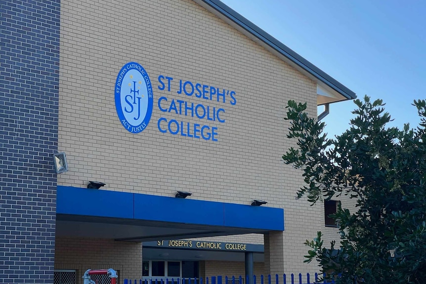 A large brick building bearing an emblem and the name "St Joseph's Catholic College".