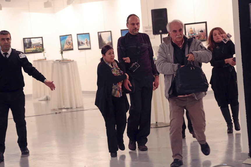 Spectators are evacuated after a gunman shot the Russian Ambassador to Turkey, Andrei Karlov, at a photo gallery in Ankara