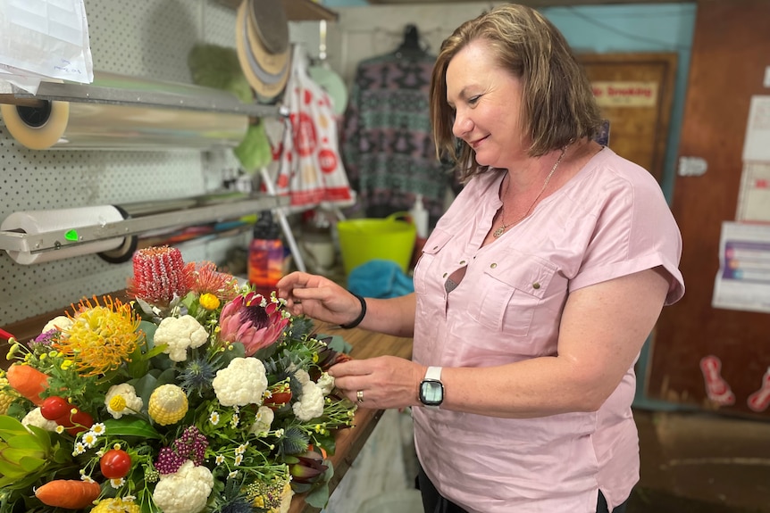 A woman draws up a bouquet of flowers.