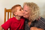 Xavier kisses his grandmother Sharon Wallace on the cheek.