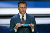 Former Italian soccer international Fabio Cannavaro holds up the team name of Australia.