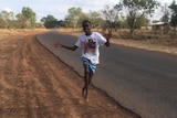 Young man runs along road waving