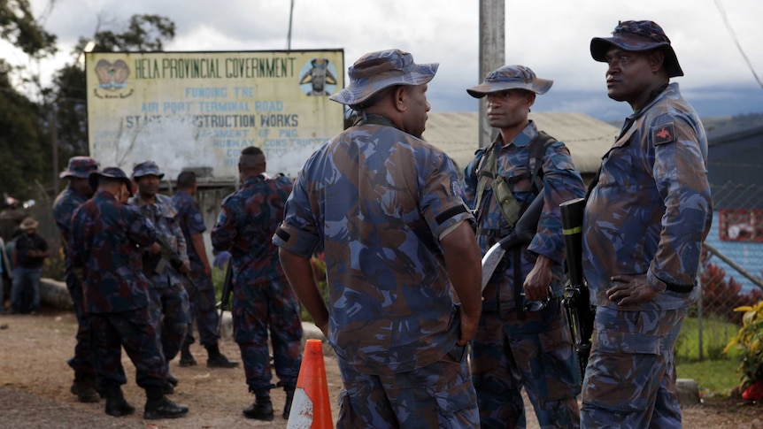 A group of police officers stand in the centre of Tari.