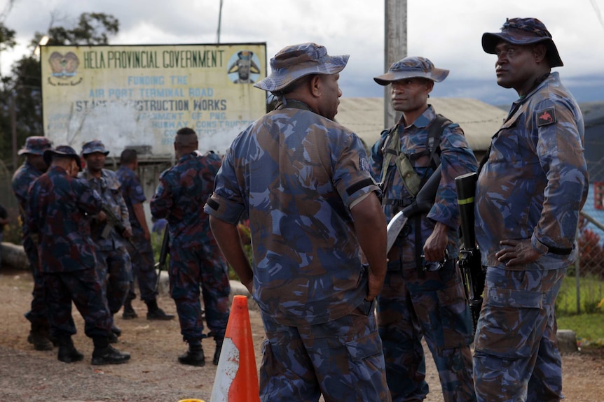 A group of police officers stand in the centre of Tari.