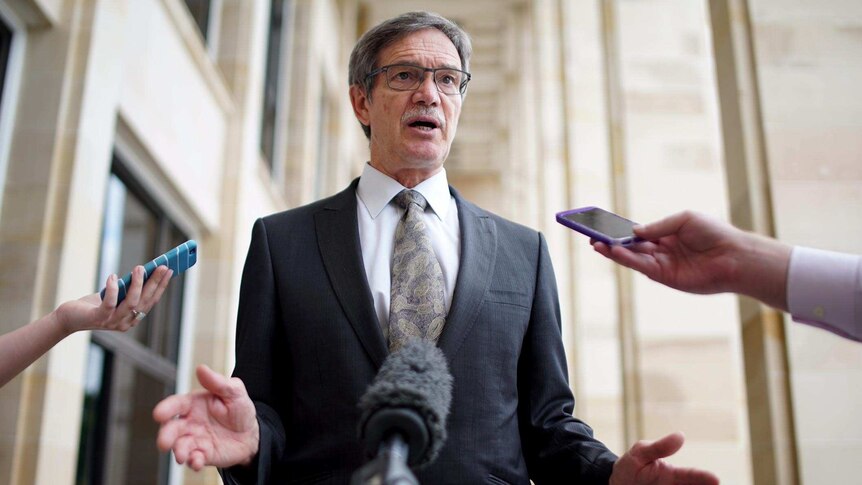 Low shot of WA Treasurer Mike Nahan, with reporters' phones outstretched, outside State Parliament in Perth