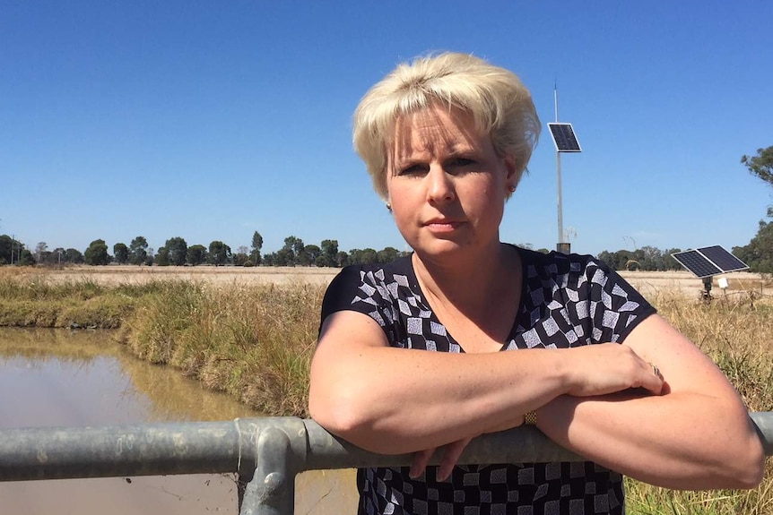 Natalie Akers stands in front of an upgraded irrigation channel behind which a solar farm is to be built.