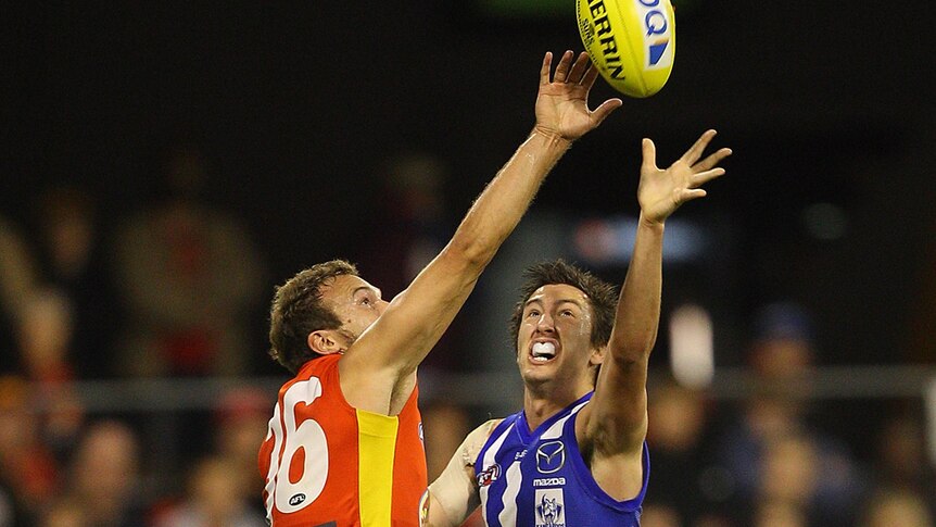The Suns' Sam Iles and the Kangaroos' Sam Wright in a fierce contest at Metricon.