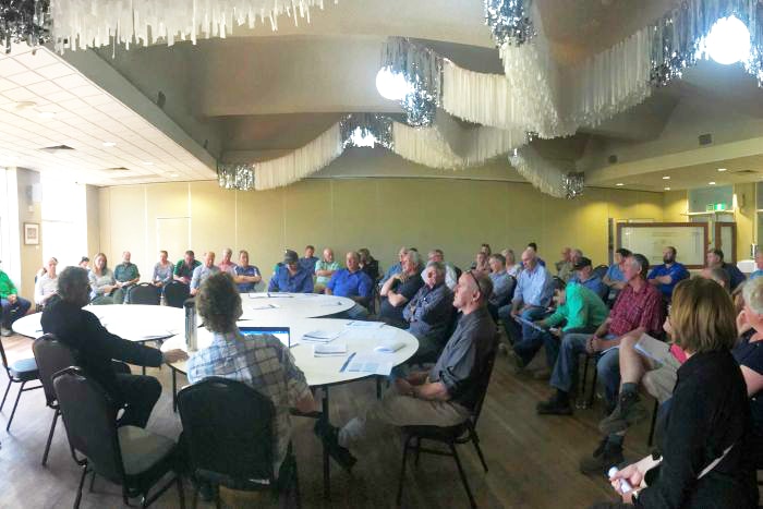 People sit in a semi circle in a large room in Finley