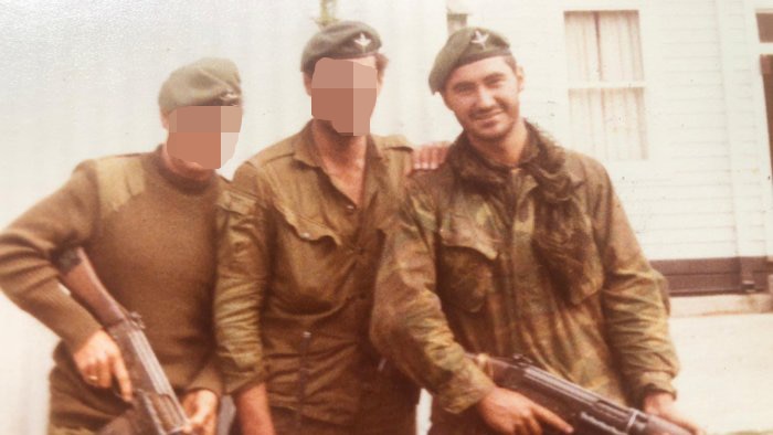 Three SAS soldiers in uniform, two with faces blurred, holding weapons.