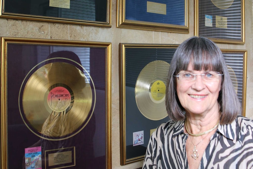 Patsy Biscoe standing in front of her gold records