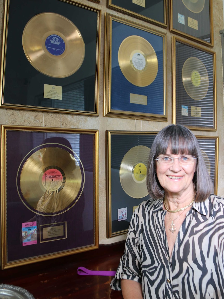 Patsy Biscoe standing in front of her gold records