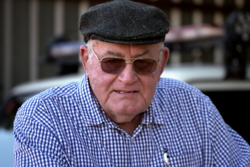 Mature aged gentleman wearing flat cap, check shirt and sunglasses.