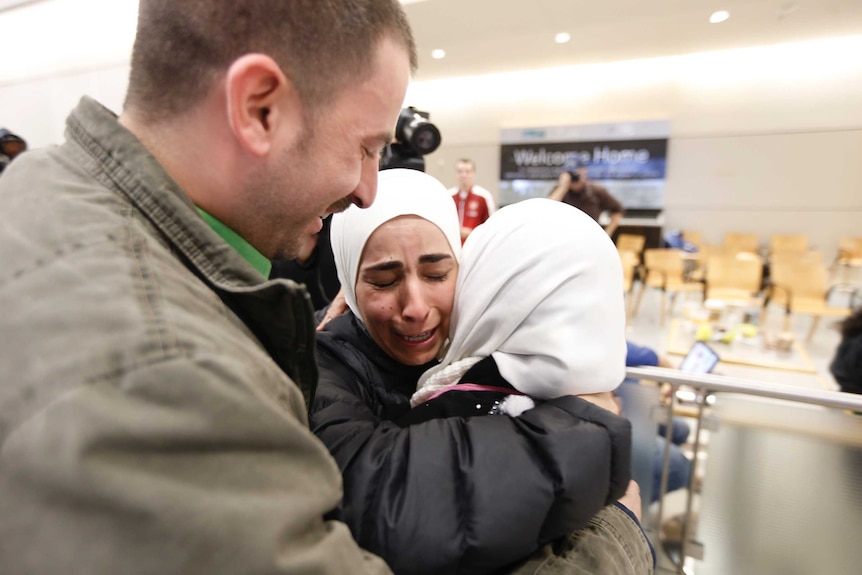 A family welcomes their mother at the airport