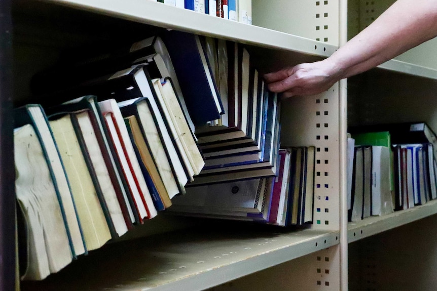 Damaged books on a library bookshelf.