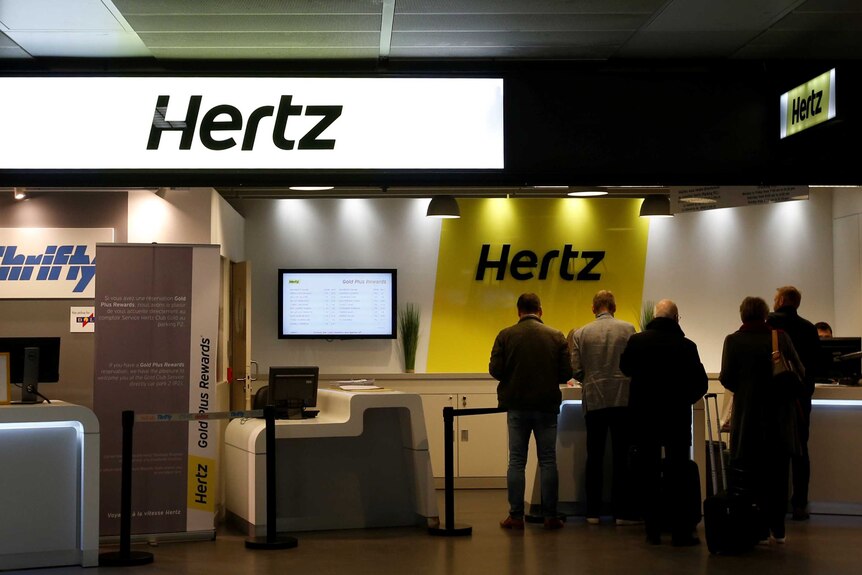 People at a Hertz counter