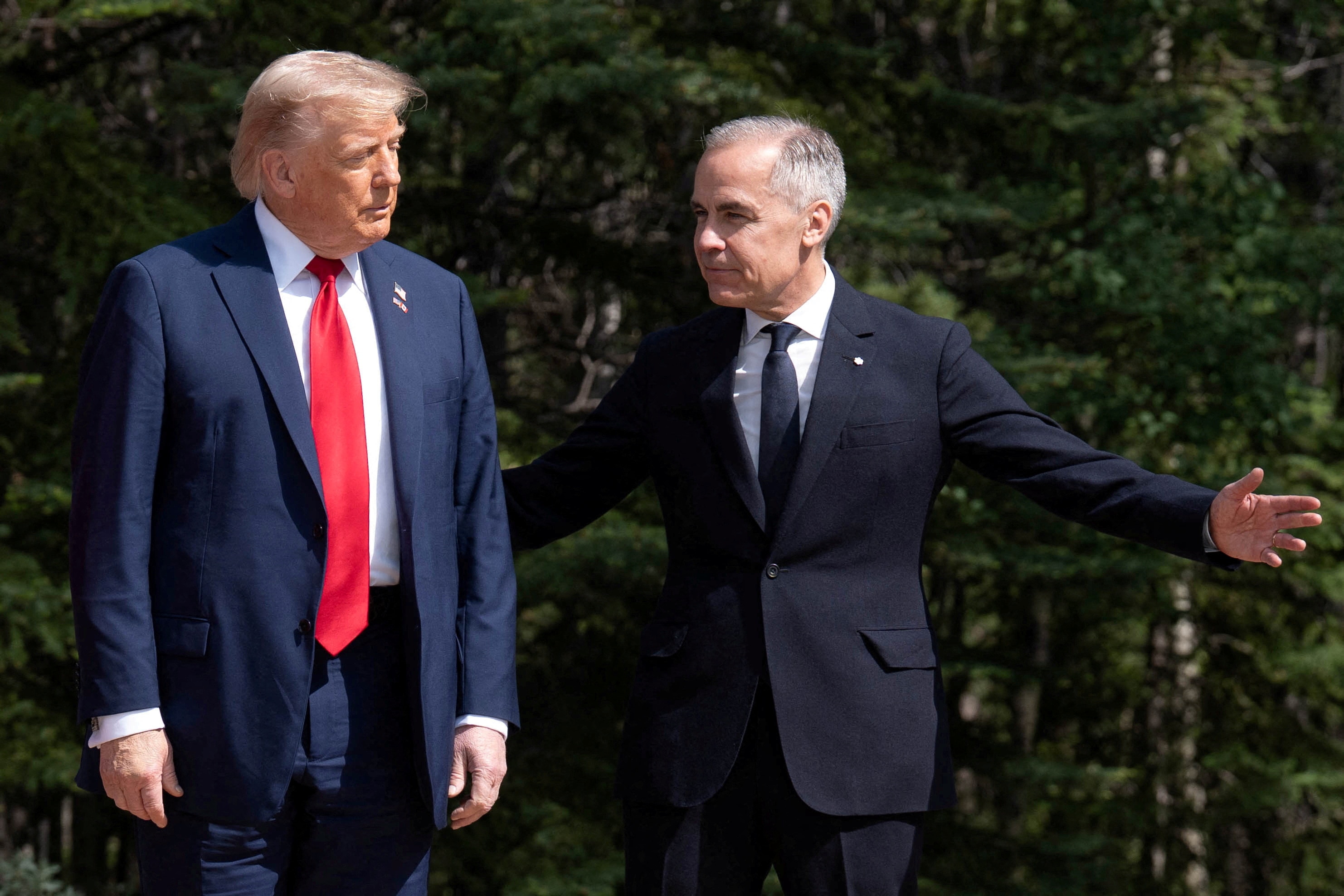 Two men stand side by side, Carney's arms are outstretched