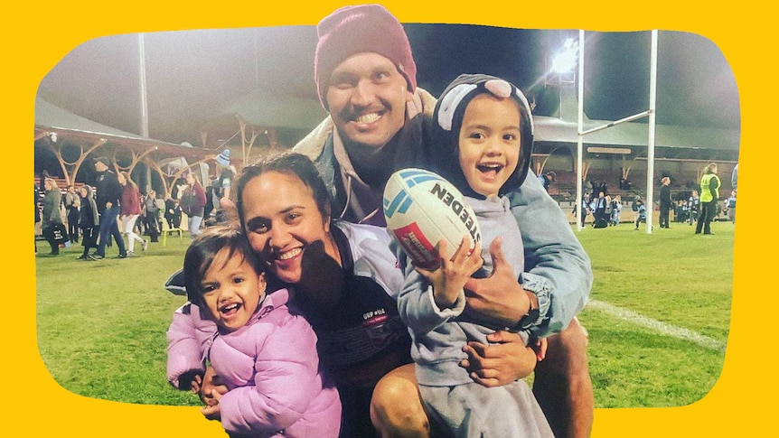 Tazmin Gray with Anthony and two kids standing on a rugby field with bright lights at night. A crowd is behind them.