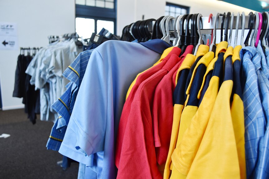A clothing rack full of colorful school uniforms