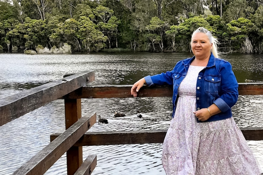 Tabatha stands on a pier over a river. 
