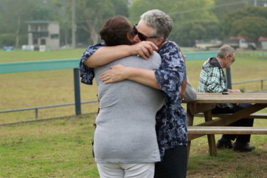 Two women embrace on the footy oval at Orbost.
