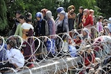 Strain: Ethnic Uzbek refugees fleeing the violence in Kyrgyzstan wait for their turn to cross the border to Uzbekistan.