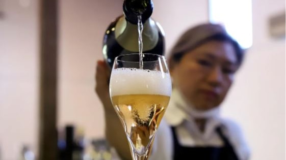 Woman pours glass of champagne