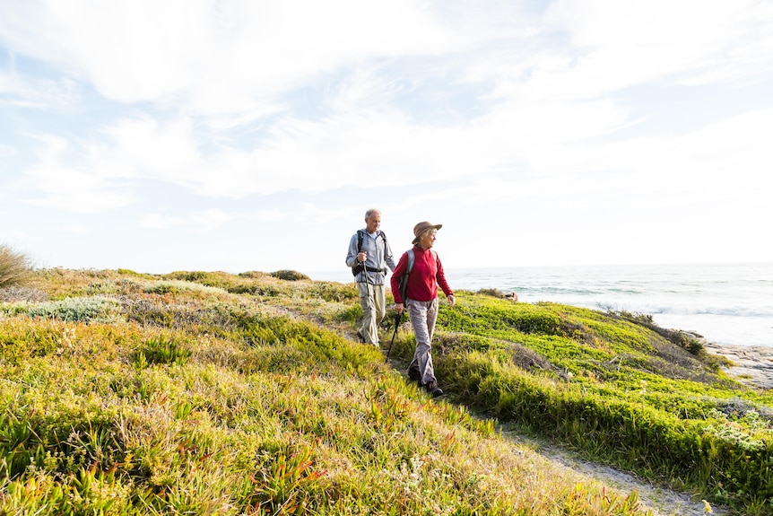Senior couple (aged 65-69) hiking together on a coastal path
