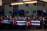 People gather behind Cuban flags near the US embassy in Havana, Cuba