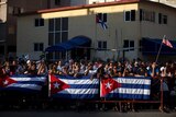 People gather behind Cuban flags near the US embassy in Havana, Cuba