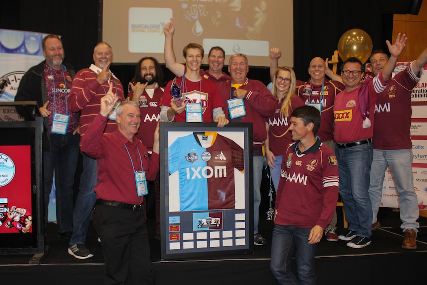 Team holds jersey and celebrates their water win.