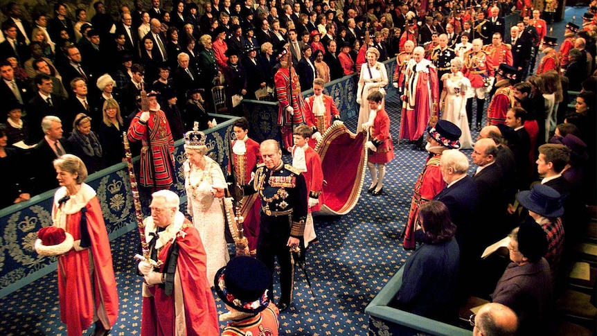 Queen Elizabeth II and Prince Philip walk through the Royal Gallery to the House of Lords.