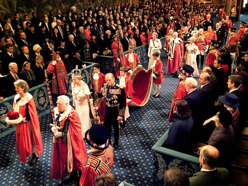Queen Elizabeth II and Prince Philip walk through the Royal Gallery to the House of Lords.