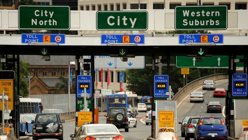 Cars on a road leading into Sydney, with toll signs above saying city north, city and western suburbs.