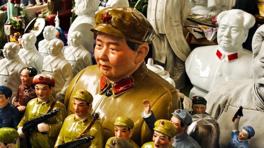 statuettes of multiple mao zedongs and figures in communist coloured uniforms